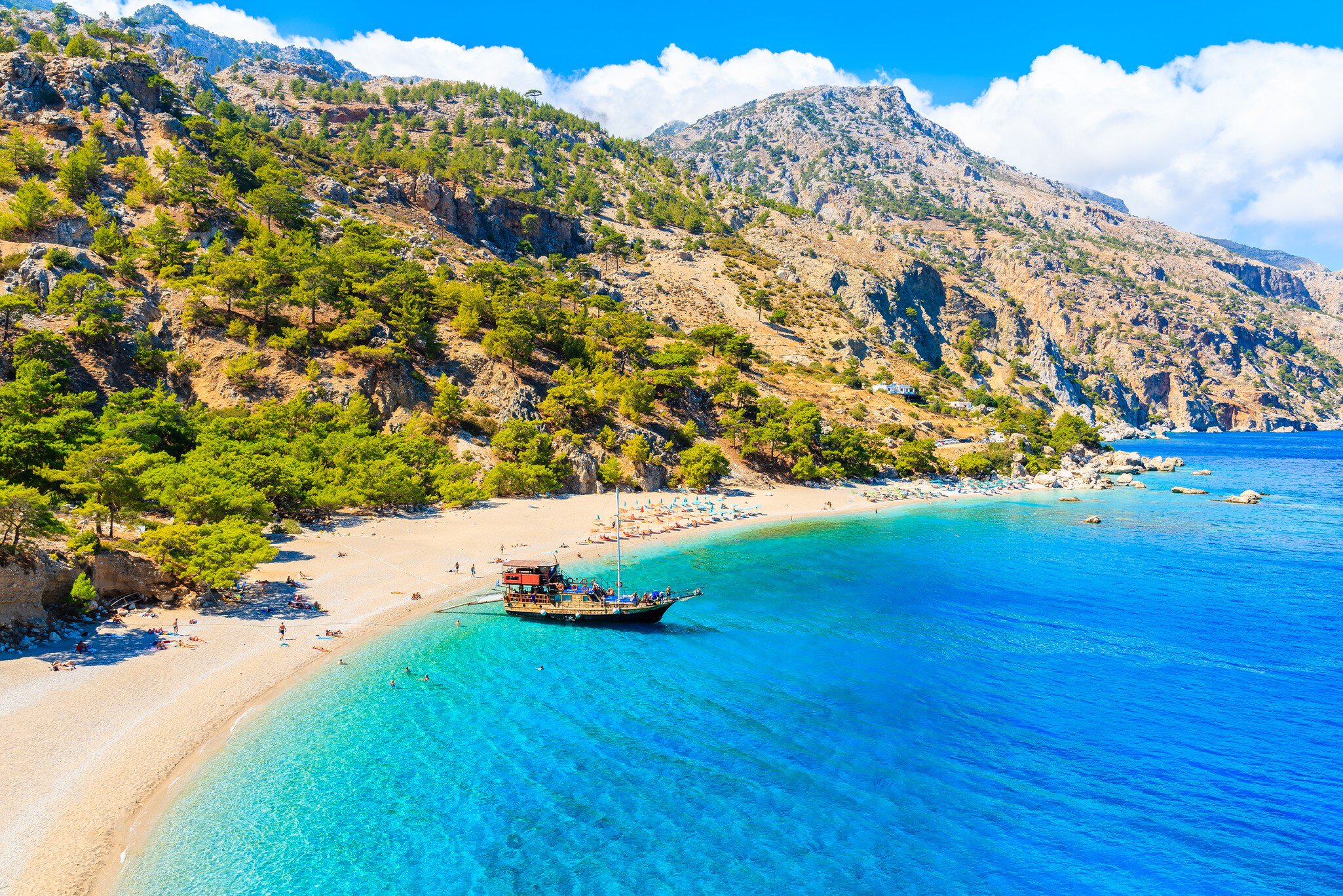 Tourist boat anchoring at beautiful Apella beach on Karpathos island, Greece; Shutterstock ID 1194560110; your: Erin Lenczycki; gl: 65050; netsuite: Digital; full: POI