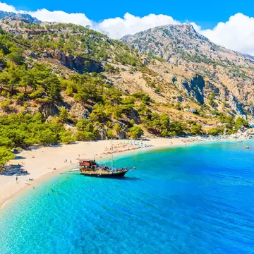 Tourist boat anchoring at beautiful Apella beach on Karpathos island, Greece; Shutterstock ID 1194560110; your: Erin Lenczycki; gl: 65050; netsuite: Digital; full: POI