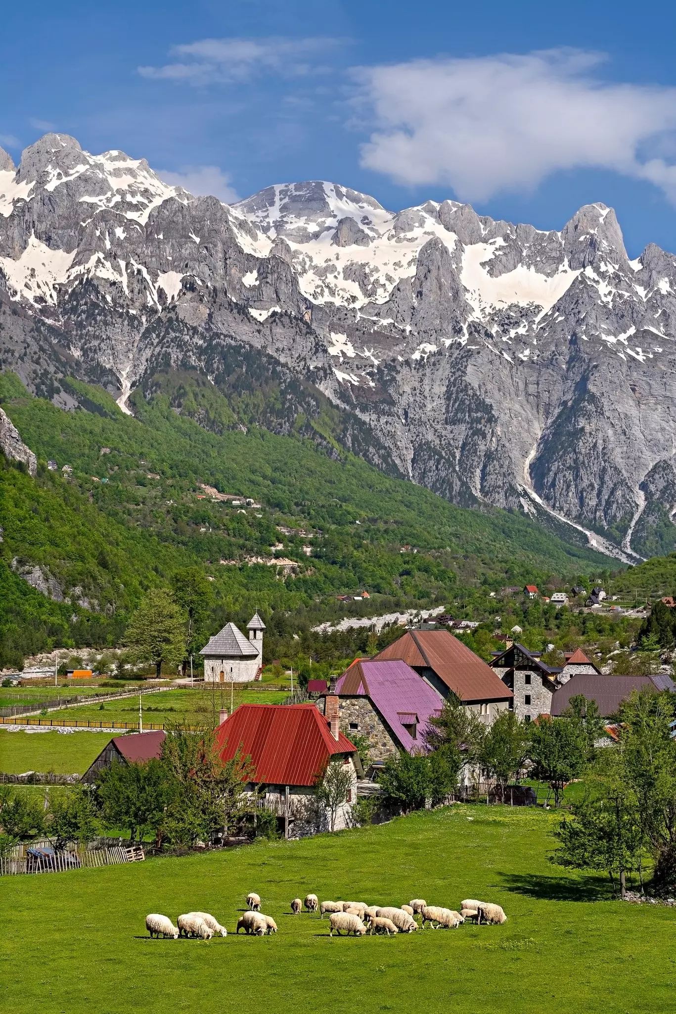 Theth Village with snow capped mountains in the Theth Valley in Albania.