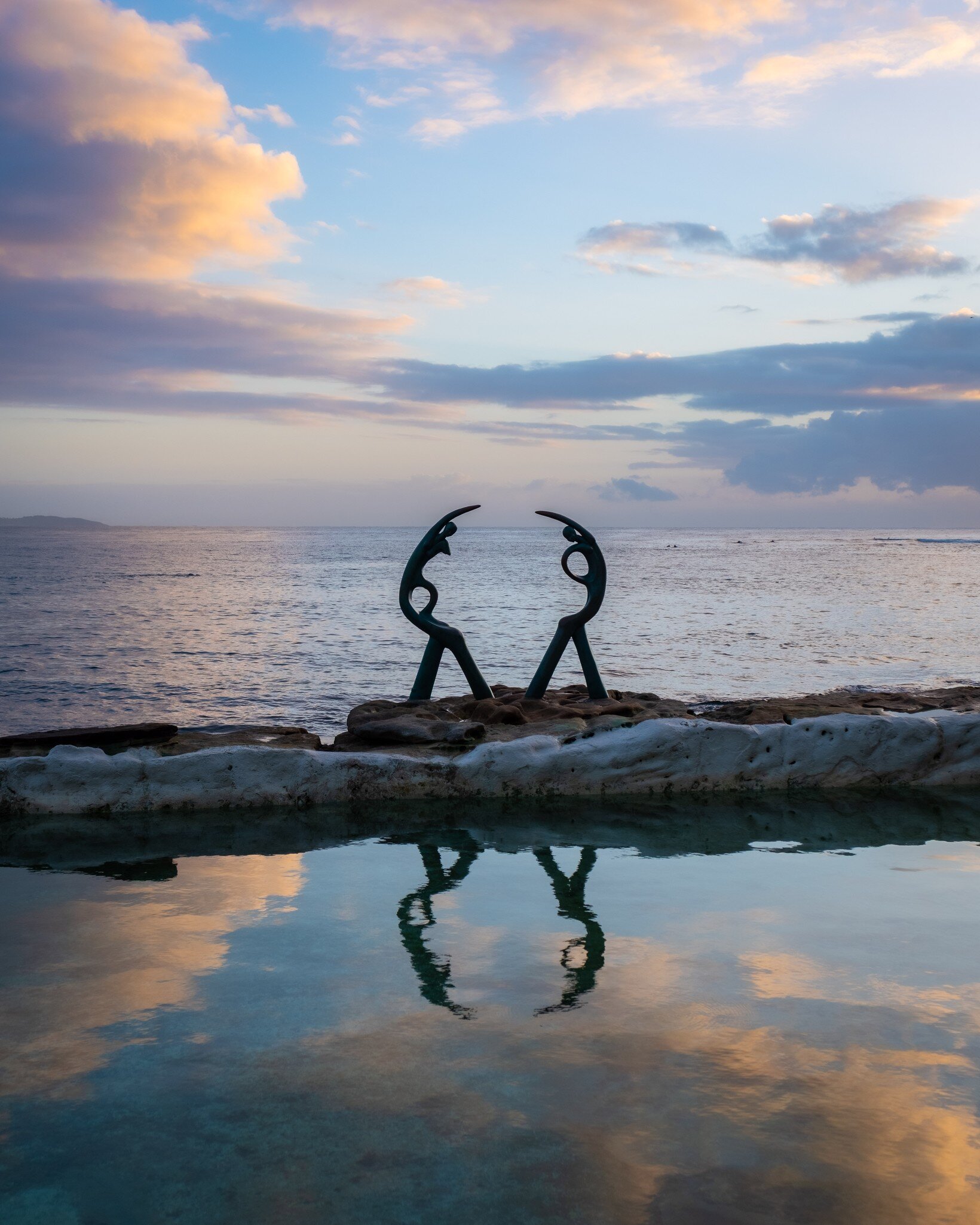 The Oceanides sculpture at Fairy Bower pool and beach, Manly, Sydney, Australia. Sunset reflection on water.