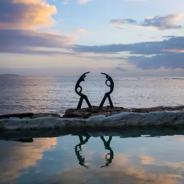 The Oceanides sculpture at Fairy Bower pool and beach, Manly, Sydney, Australia. Sunset reflection on water.