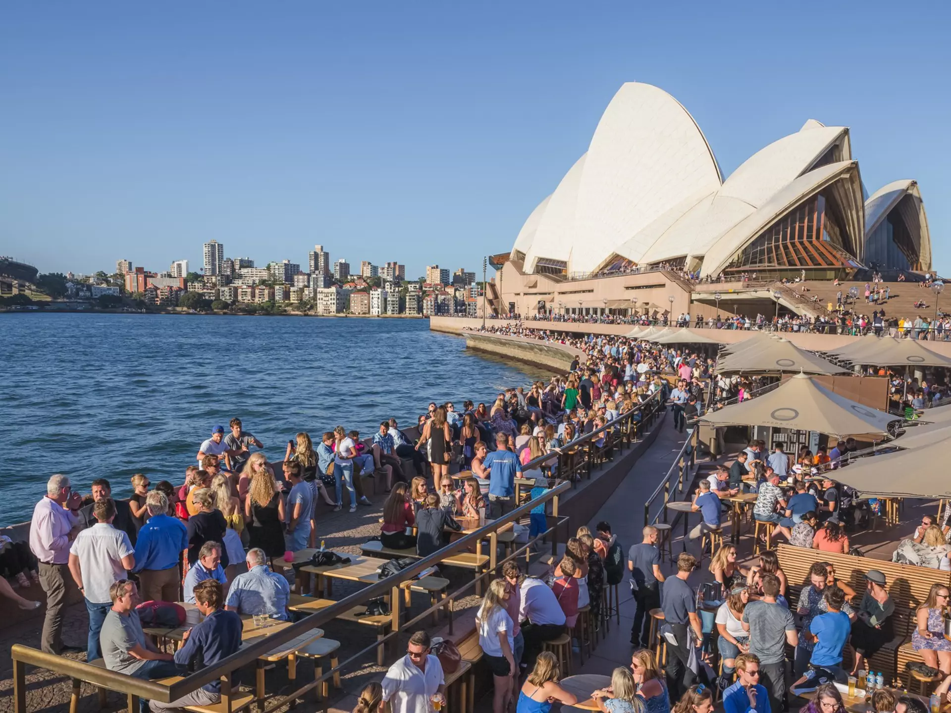 A busy Sydney Harbour leading up to the Opera House as both locals and tourists alike enjoy some drinks and socialising at Opera Bar.