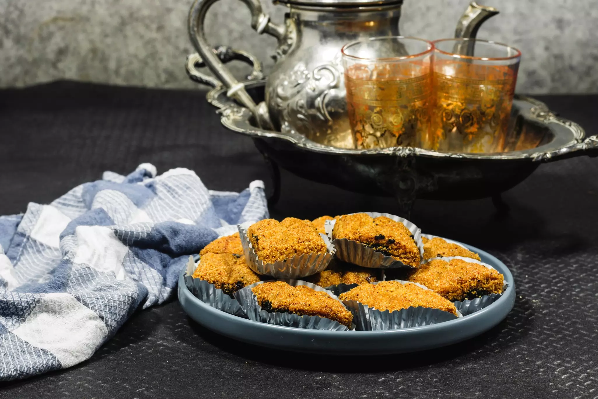 A plate loaded with honeyed desserts and a tray of tea.