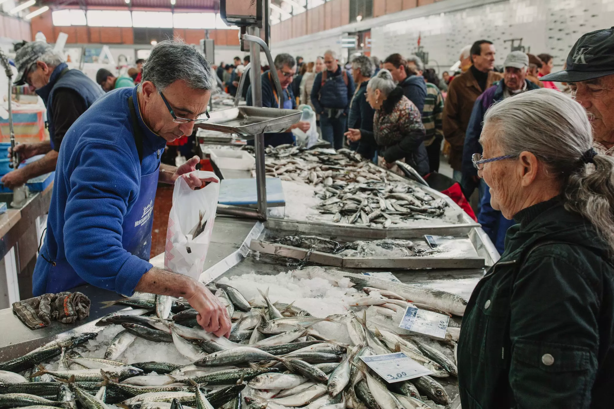 Vendors and shoppers in a busy fresh fish market.