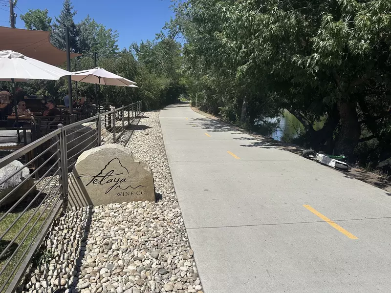 The path of the Greenbelt with the patio of Telaya Winery next to it in Boise, Idaho
