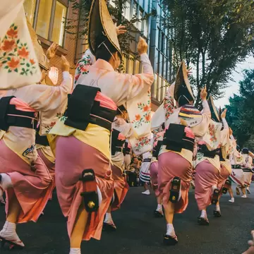 A procession of dancers in on a street during a festival in Kagurazaka, Tokyo, Japan