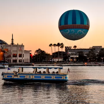 Orlando, Florida. January 11, 2019 Panoramic view  of Disney Springs and water taxi on colorful sunset background at Lake Buena Vista area  (1)  License Type: media  Download Time: 2021-02-25T18:03:39.000Z  User: AHoward_lonelyplanet  Is Editorial: Yes  purchase_order:   