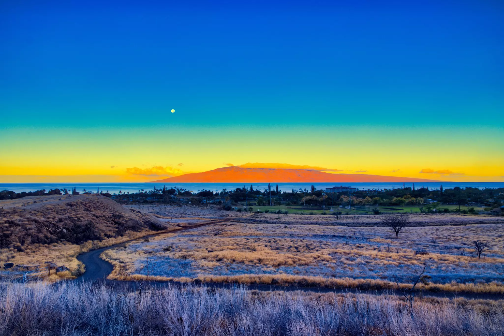 Surrealistic moonset over Lahaina on Maui with Lanai in the distance.