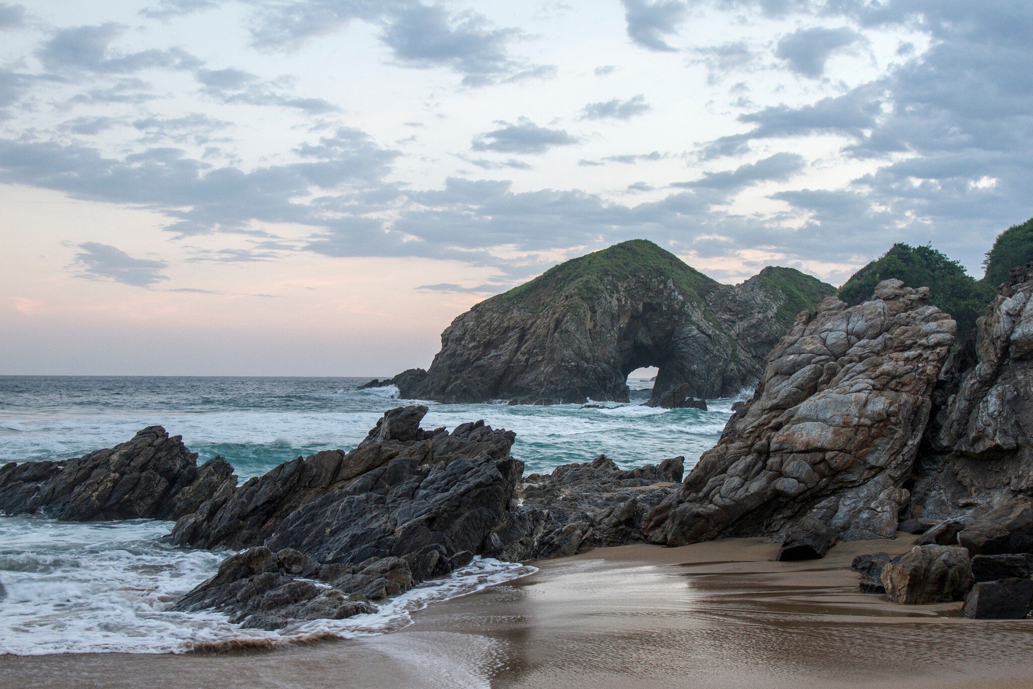 Sunset at the touristic Zipolite beach in Oaxaca,  Mexico.  Rocky beach with no people.; Shutterstock ID 2275510841; your: Sloane Tucker; gl: 65050; netsuite: Online Editorial; full: POI