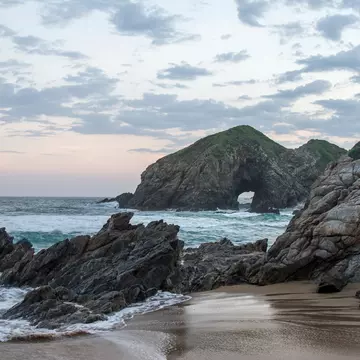 Sunset at the touristic Zipolite beach in Oaxaca,  Mexico.  Rocky beach with no people.; Shutterstock ID 2275510841; your: Sloane Tucker; gl: 65050; netsuite: Online Editorial; full: POI