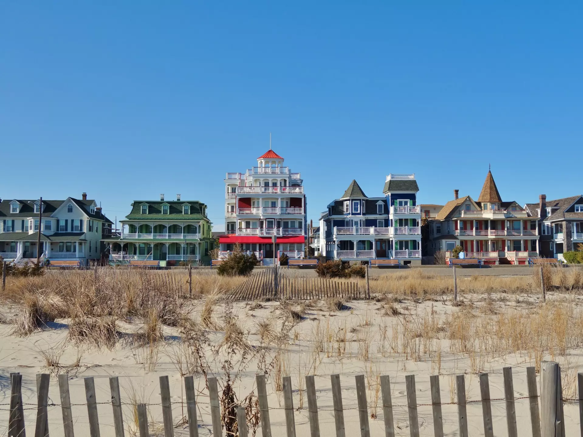 Colorful historic Victorian houses line the beachfront in Cape May, at the southern tip of Cape May Peninsula in New Jersey where the Delaware Bay and Atlantic Ocean meet. 