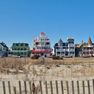 Colorful historic Victorian houses line the beachfront in Cape May, at the southern tip of Cape May Peninsula in New Jersey where the Delaware Bay and Atlantic Ocean meet. 