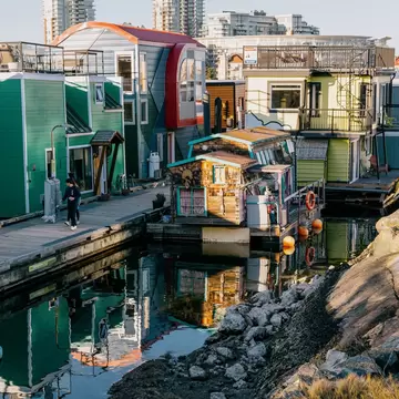 Victoria, Canada - Mar 17 2024: A row of colorful floating houses at Fisherman's Wharf, catching beautiful sunlight reflected from the sea, their own reflections visible on the calm water., License Type: media, Download Time: 2026-05-14T15:32:35.000Z, User: LP_NZhan, Editorial: true, purchase_order: 65050 - Digital Destinations and Articles, job: App Content, client: Lonely Planet APP, other: Nadine Zhan