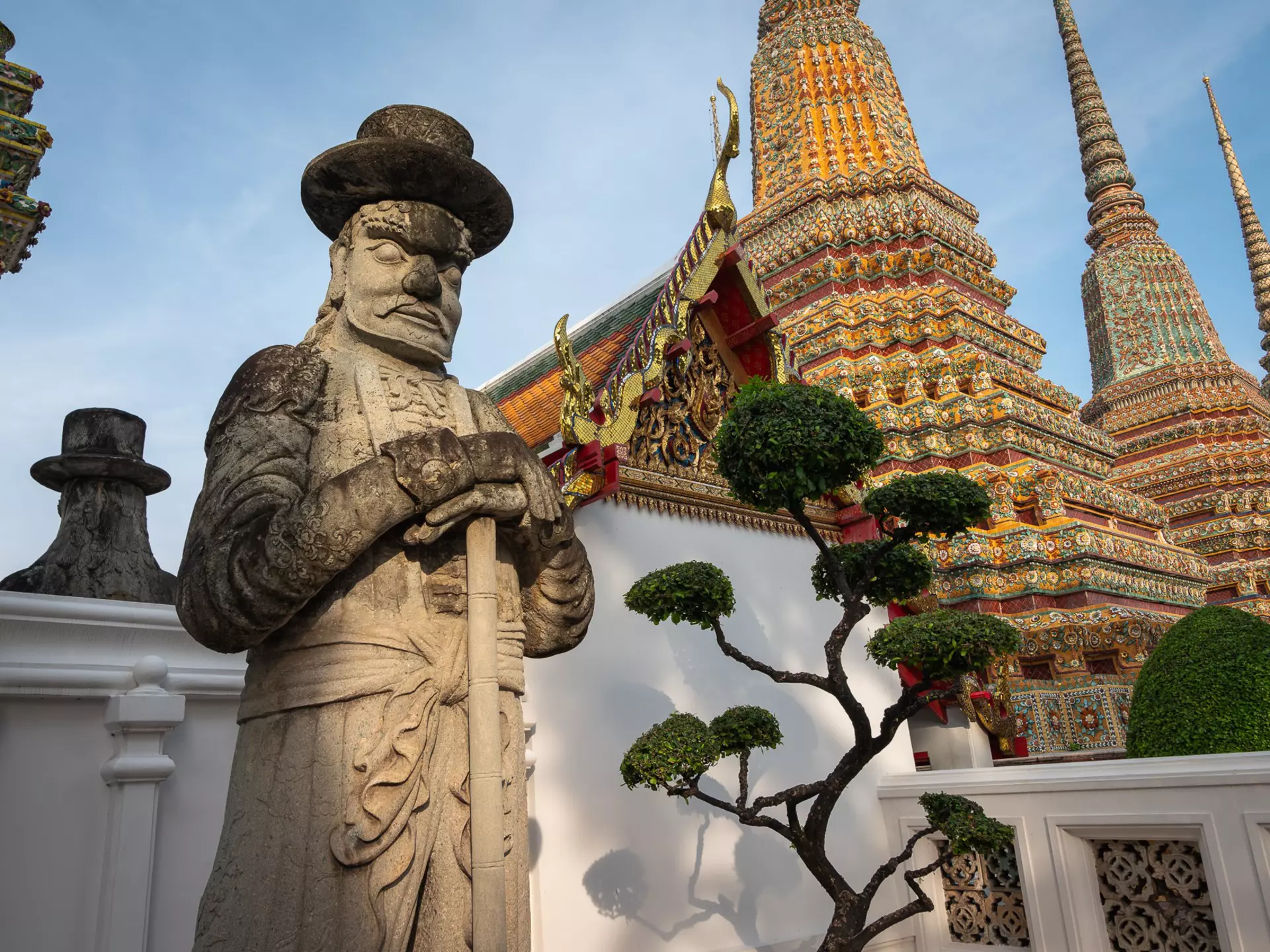 A statue in front of a temple complex.