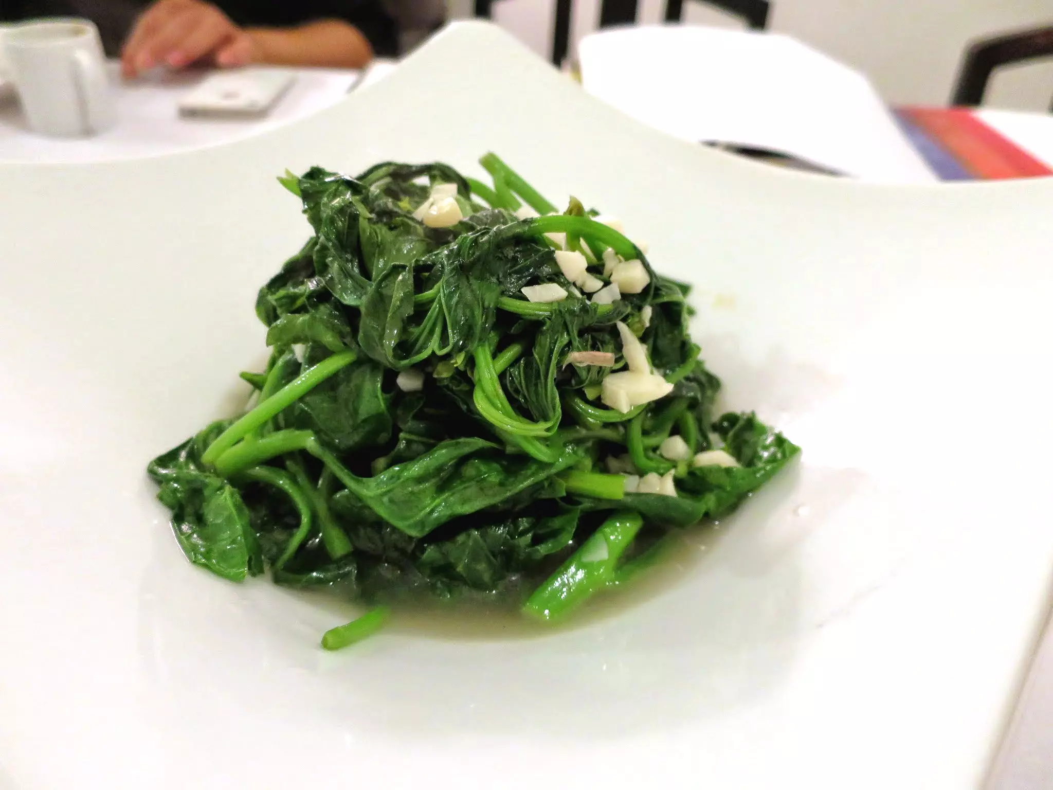 Fried greens with garlic in a restaurant in Hong Kong.