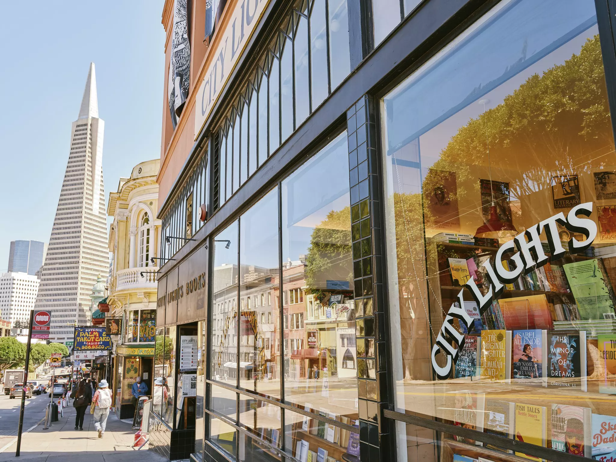 A bookstore's display window with a pyramid-topped skyscraper in the background.