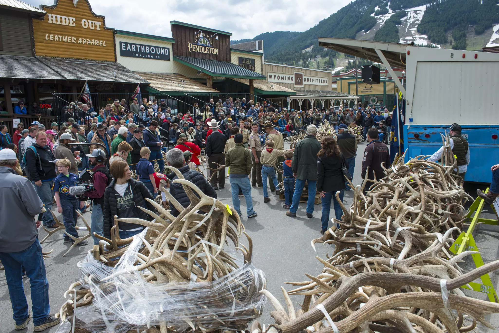 Piles of elk antlers in a street as buyers browse at a festival