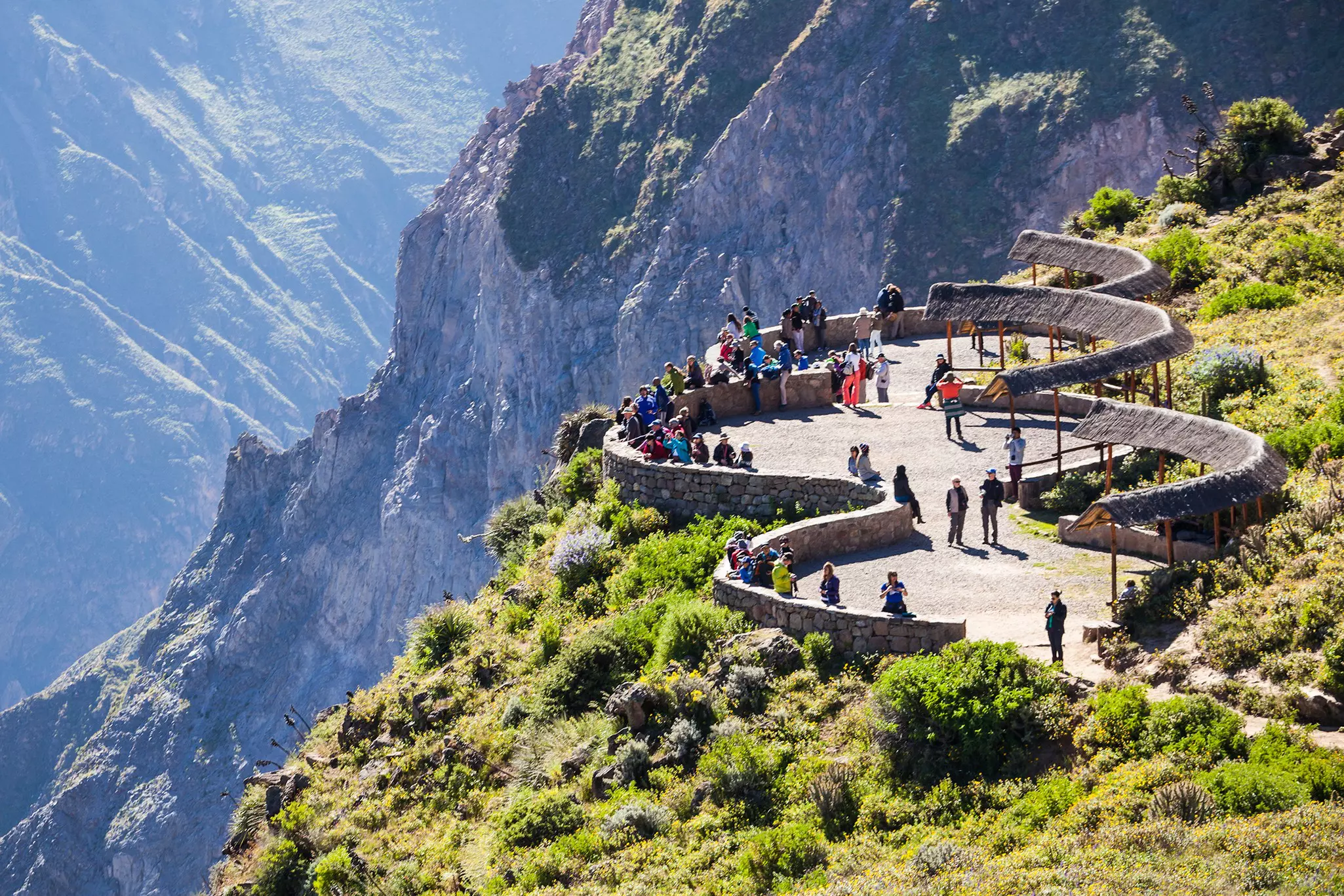 An aerial view of people walking on a platform overlooking a canyon