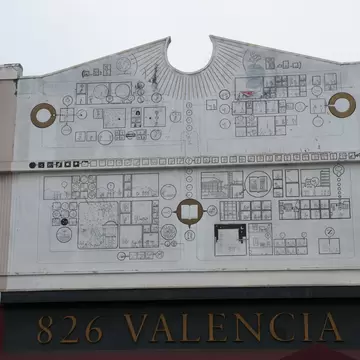 Scalloped parapet covered in line drawings above the 826 Valencia storefront
