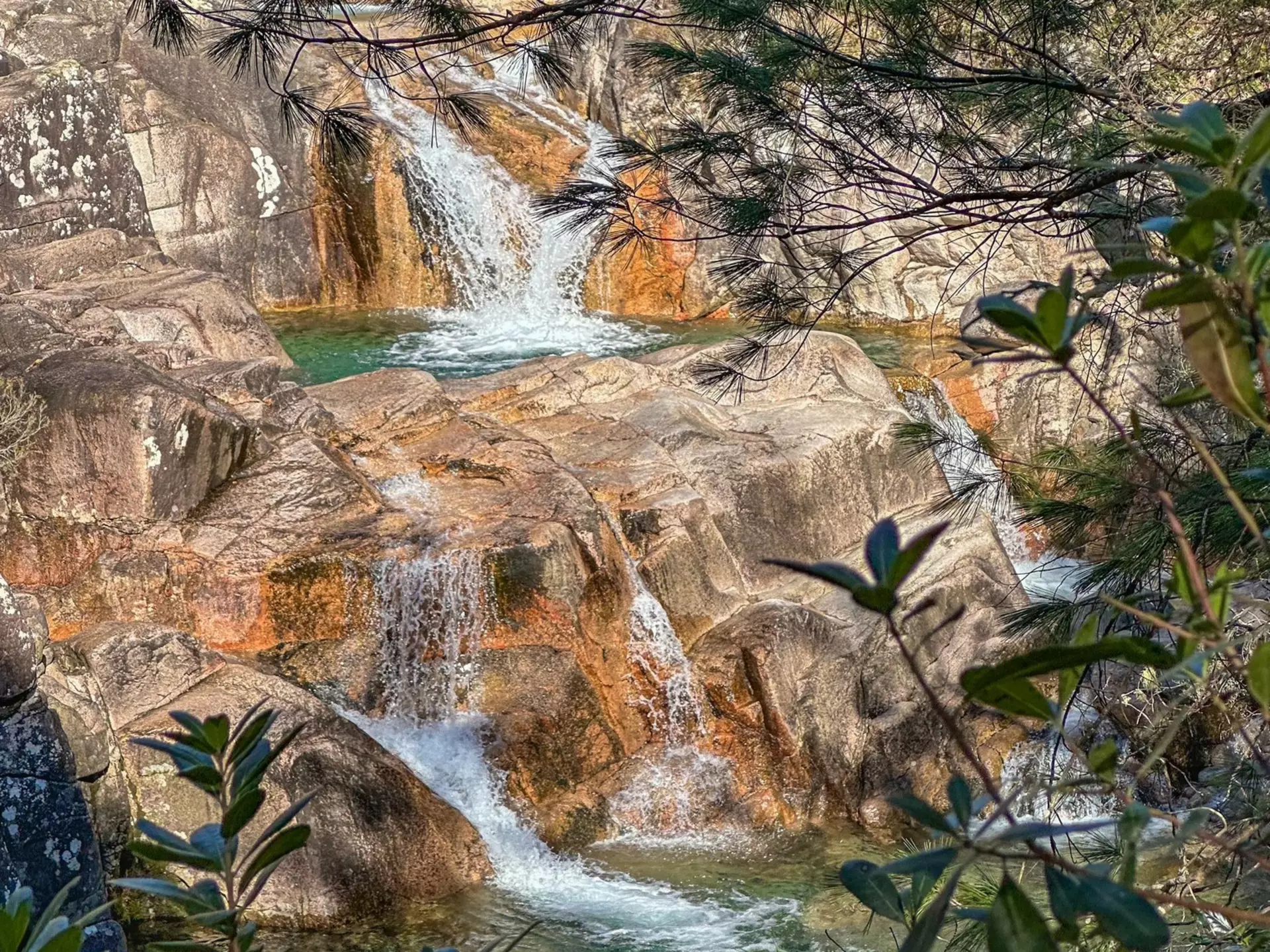 A multilevel waterfall with pools of water in rock.