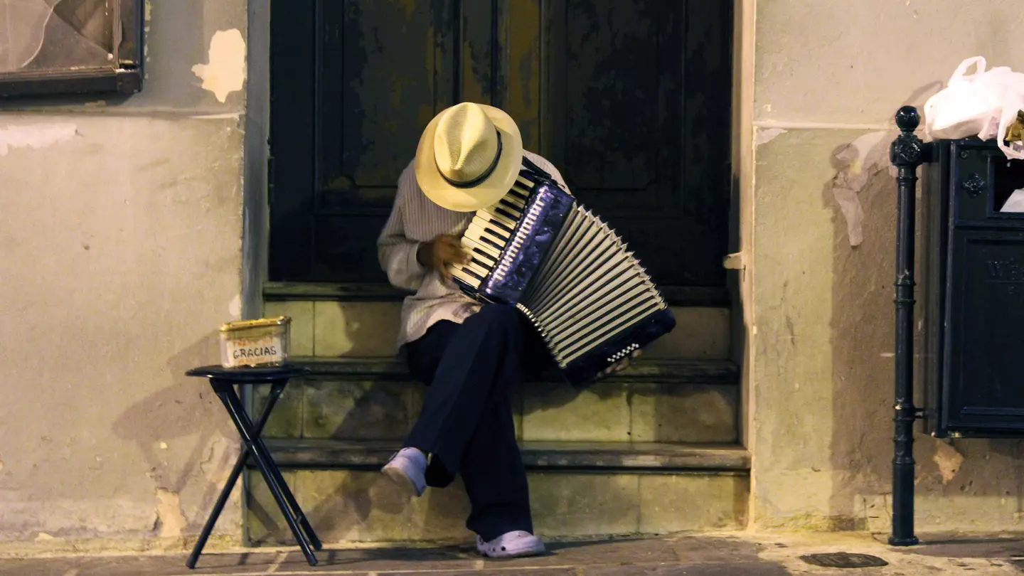 Man in a straw hat playing an accordion in Old San Juan