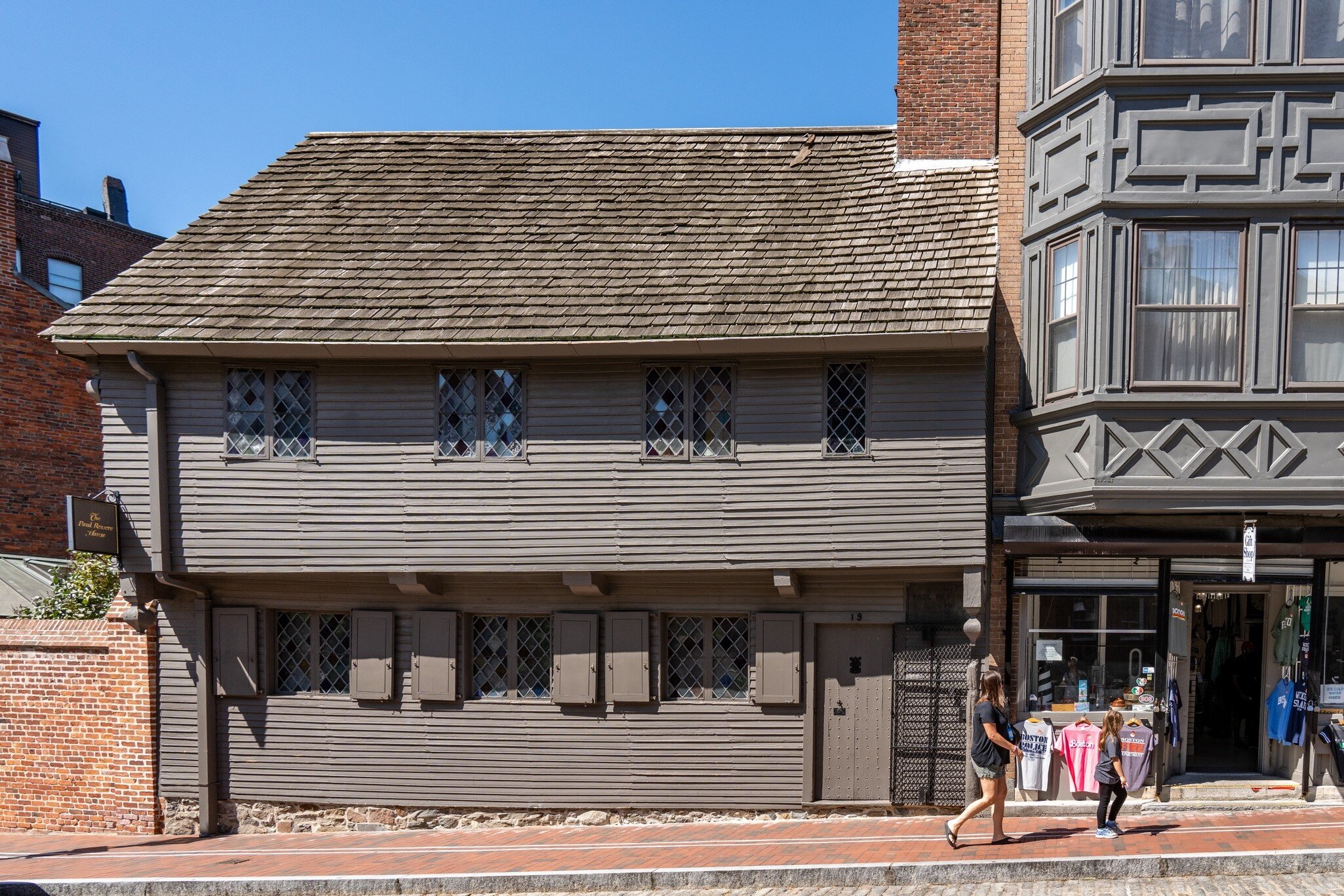 A woman walks by the Paul Revere House in Boston, Massachusetts.
