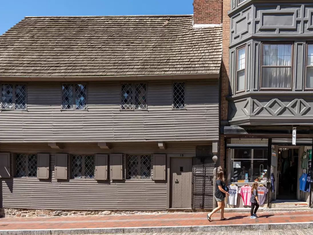 A woman walks by the Paul Revere House in Boston, Massachusetts.