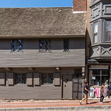 A woman walks by the Paul Revere House in Boston, Massachusetts.