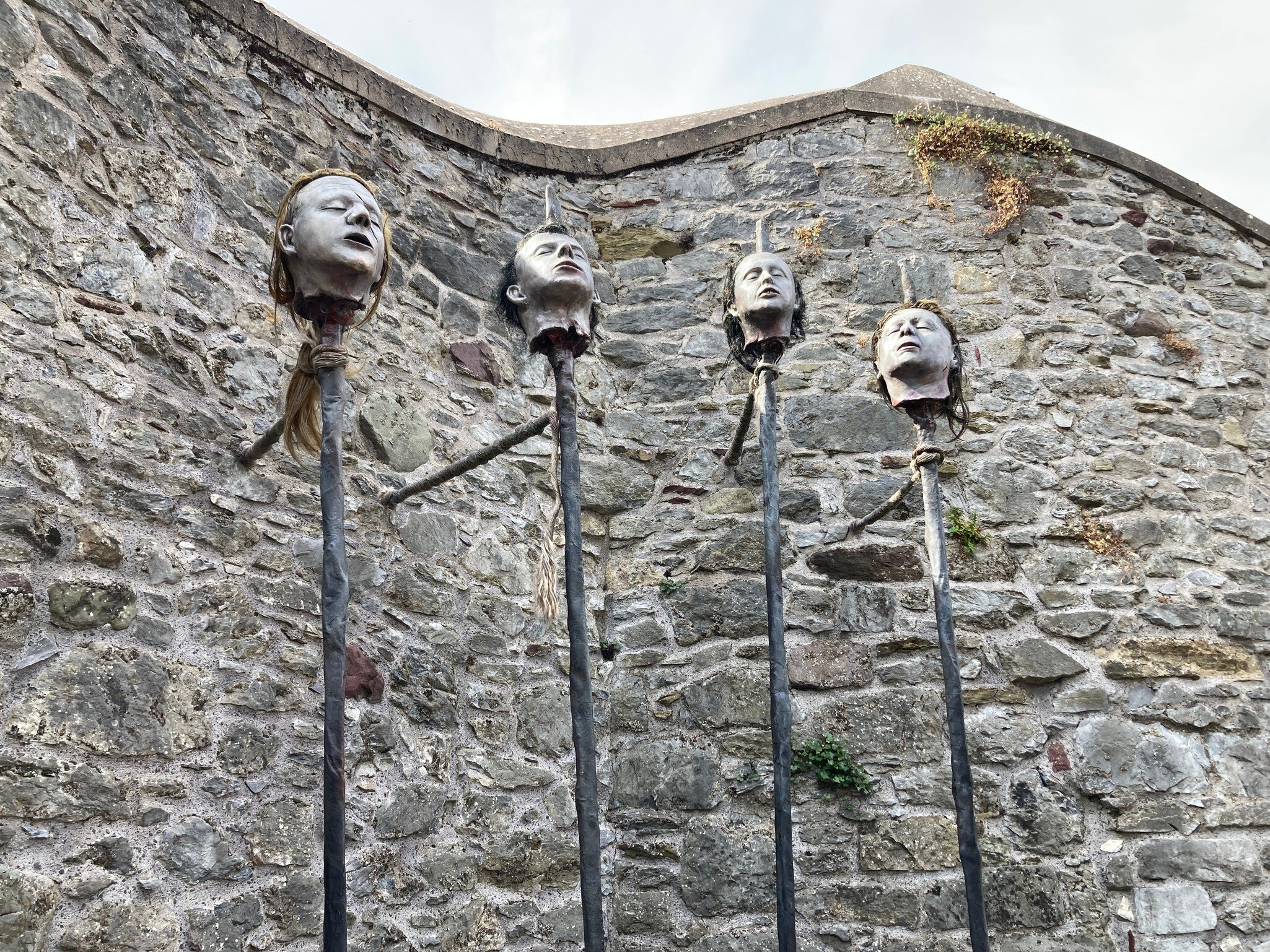 Elizabeth Fort in the centre of the Irish city of Cork, Ireland.  A sculpture of four men's heads, tethered to a brick wall.