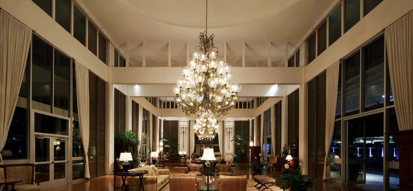 A vast hotel lobby with a low-hanging crystal chandelier