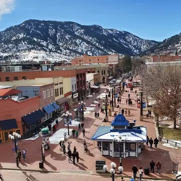 Pedestrians walk down a main shop-lined street on a winter's day: Pearl St, Boulder.
