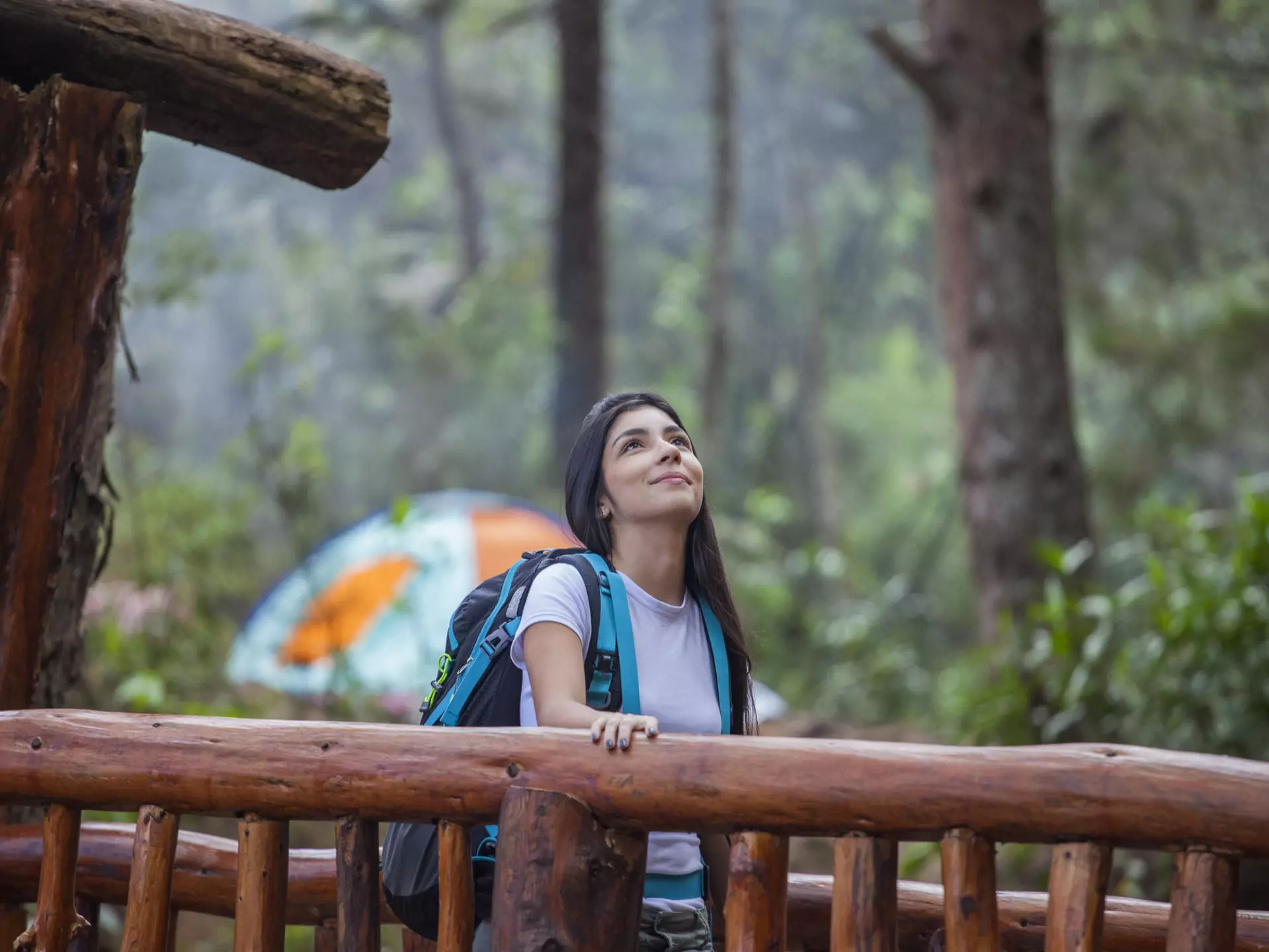 A woman walks over a wooden bridge in Parque Arví, Medellín