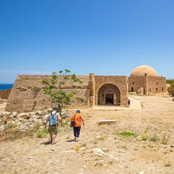 An elderly tourist couple visits the Medieval fortifications in Rethymno fortress during the summer months.