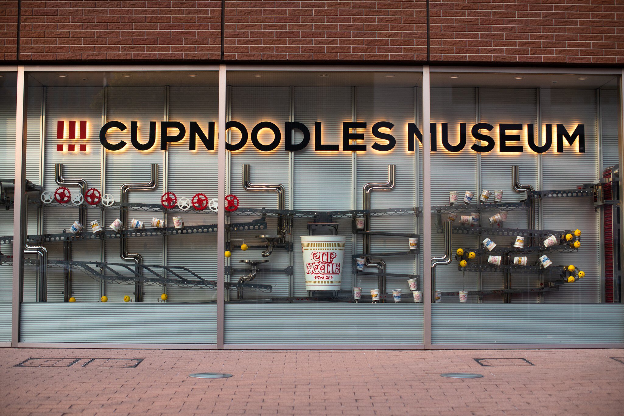 A glass museum frontage with CUPNOODLES MUSEUM lettering above displays.