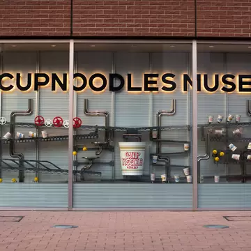 A glass museum frontage with CUPNOODLES MUSEUM lettering above displays.