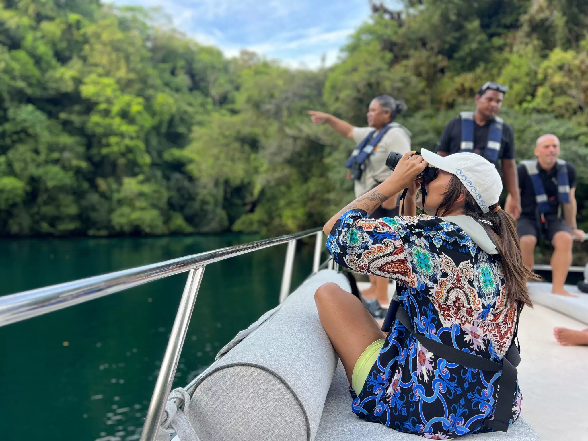 A woman with binoculars birdwatching from a boat in Palau.