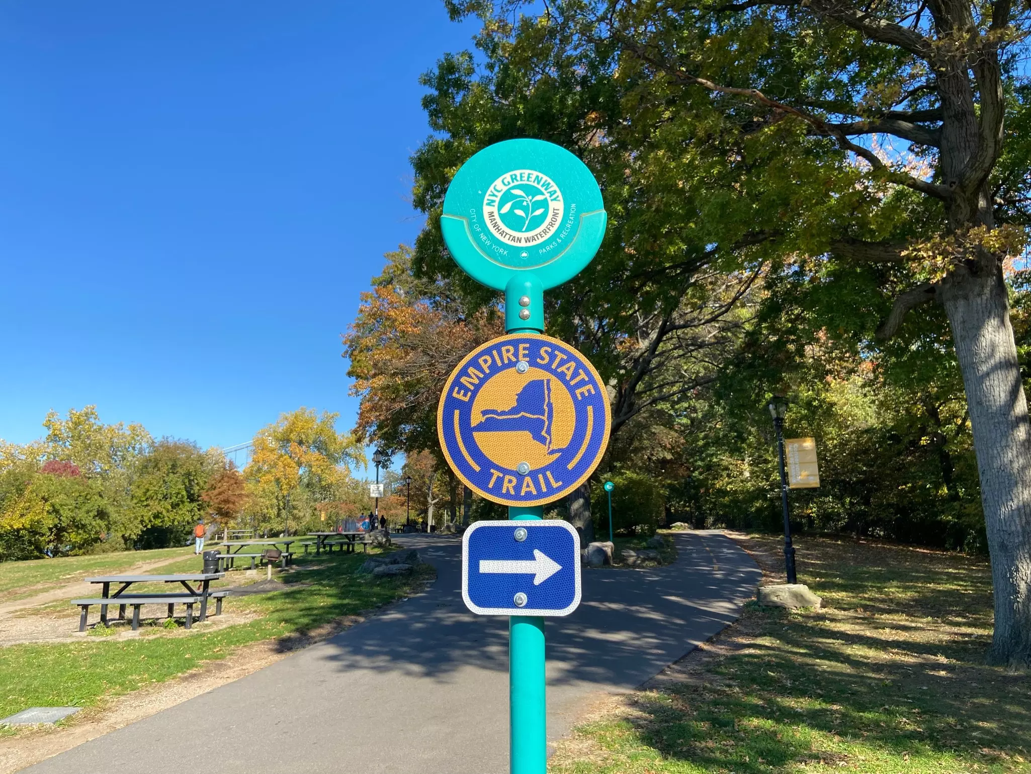 Signs for the NYC Greenway and Empire State Trail on a bicycle path in Riverside Park, Manhattan