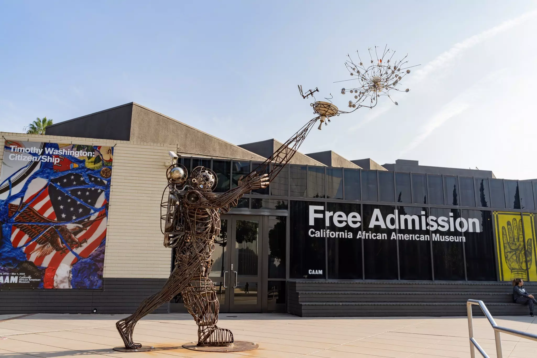 A large wire statue in the form of an astronaut releasing something into the air