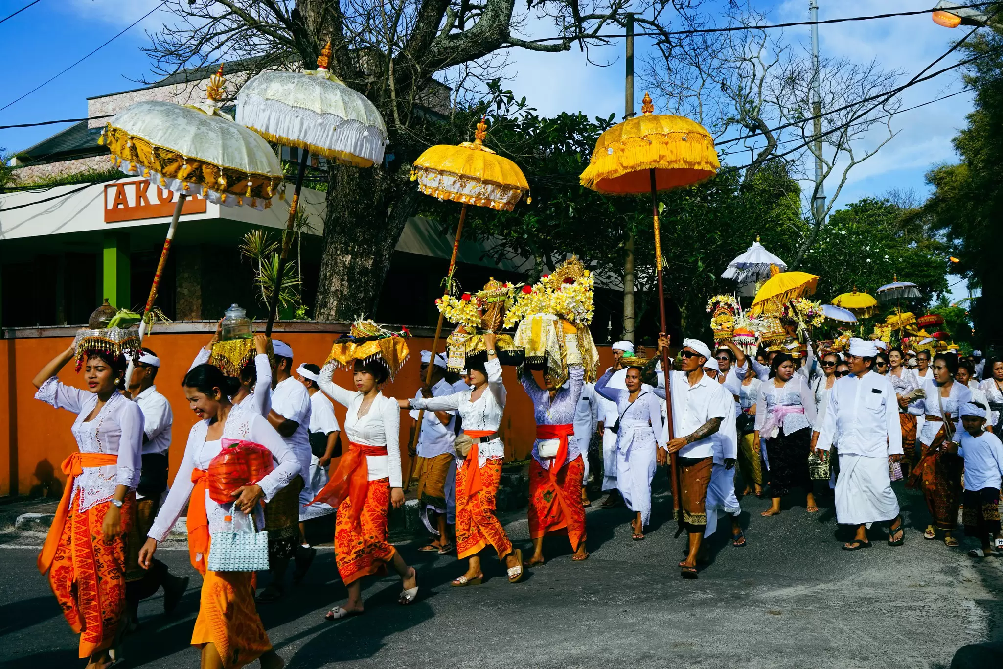 Islanders with colorful clothing and umbrellas take part in a Melasti procession near Jimbaran in Bali during Nyepi. 