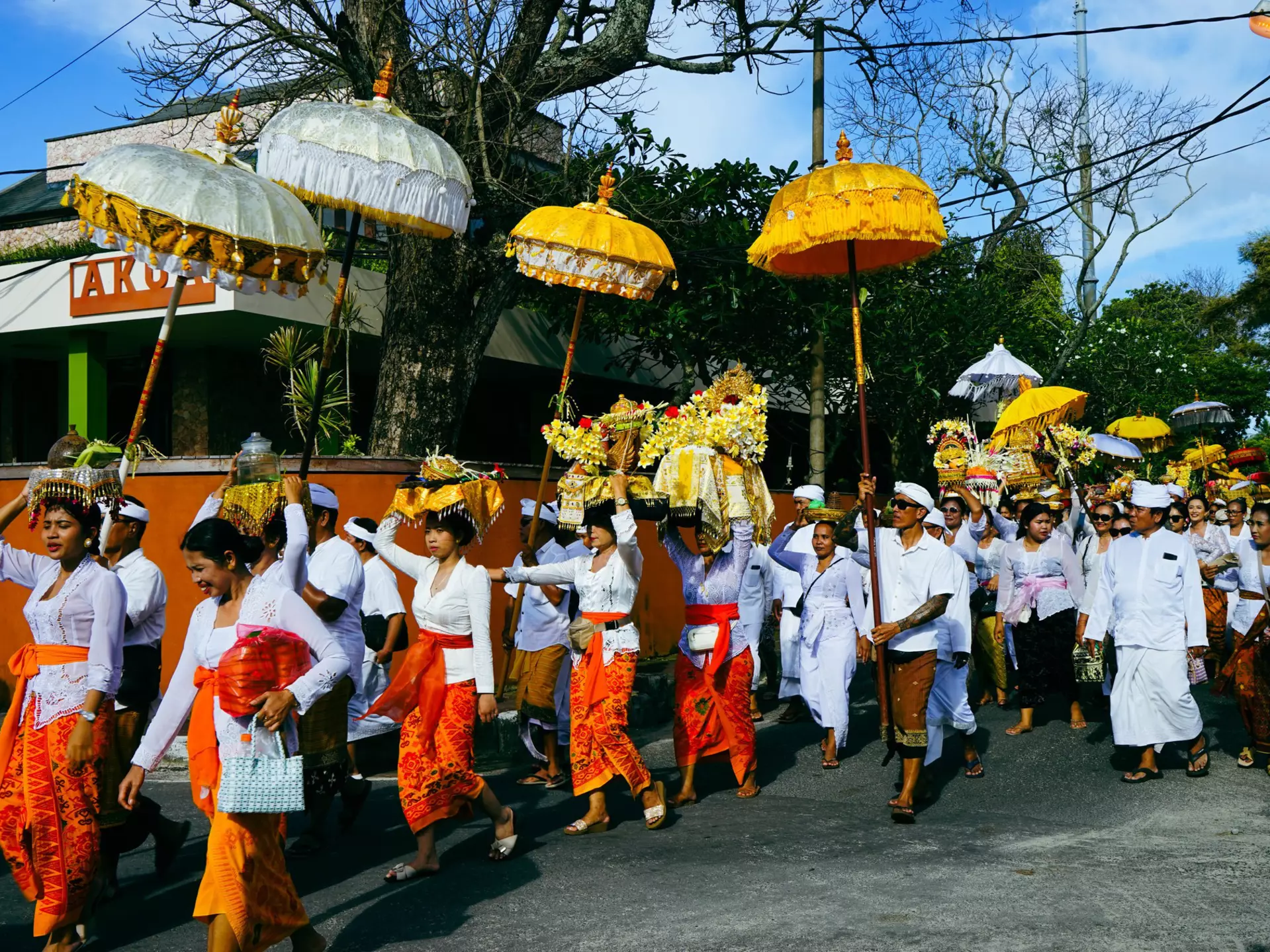 Islanders with colorful clothing and umbrellas take part in a Melasti procession near Jimbaran in Bali during Nyepi. 