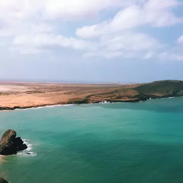 An aerial view of turquoise ocean hitting a desert coastline in La Guajira, Colombia
