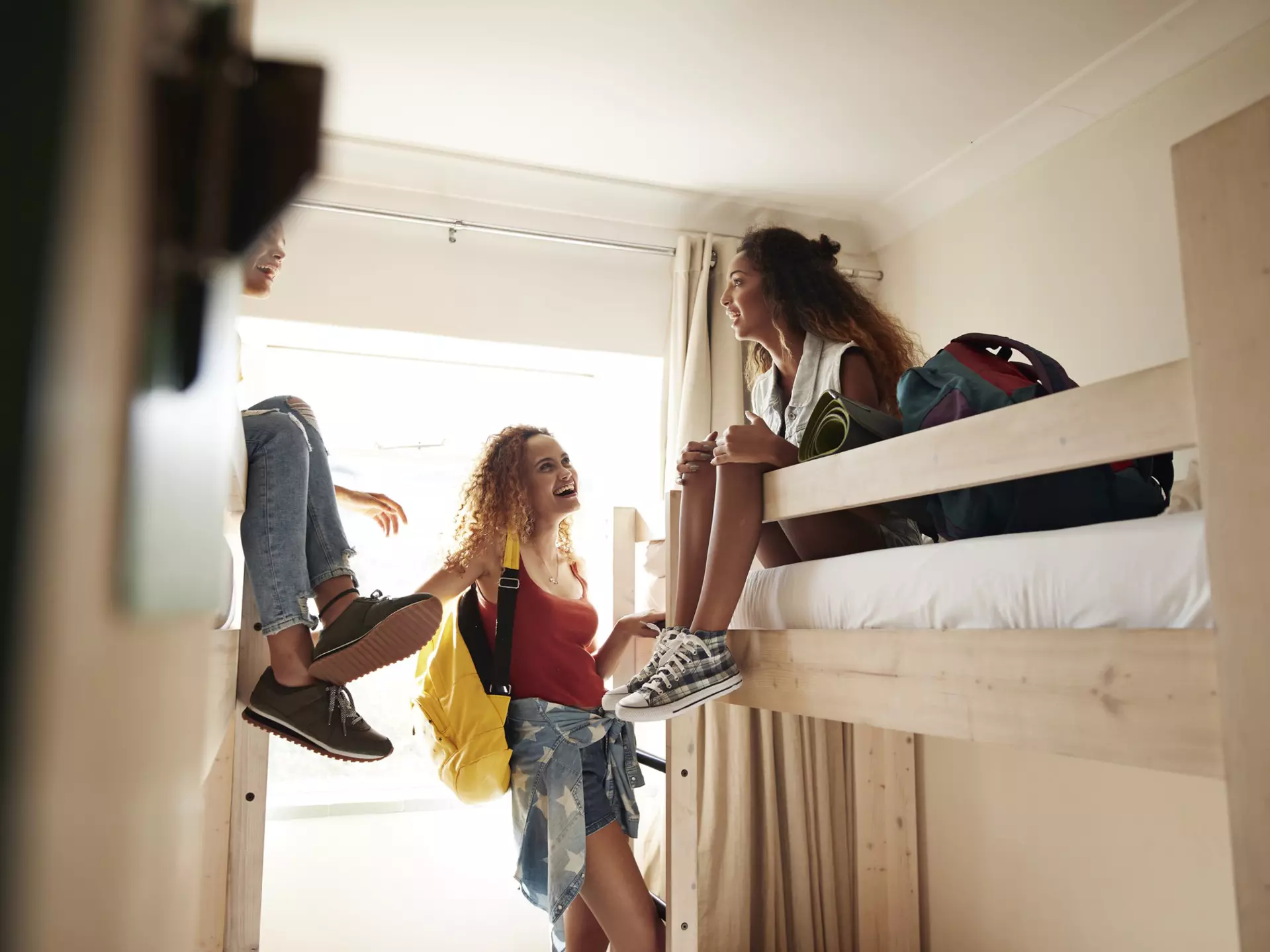 Young women arriving to room with bunk beds, at youth hostel