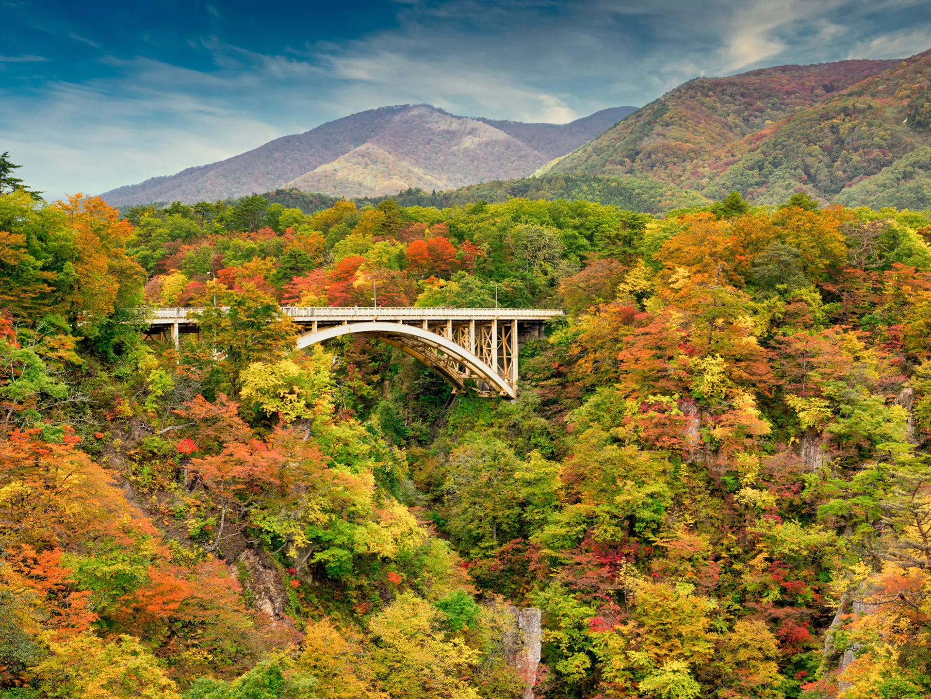 The Ofukazawa bridge offers autumn views of Naruko Gorge from Narukokyo Resthouse. It spans the gorge, ending the walking trail with elevated views of Tohoku's fall colors.