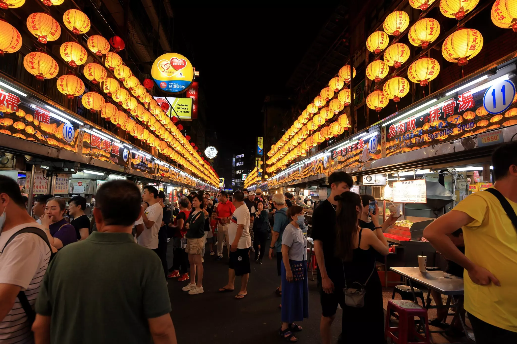 A group of people shopping at a night market. 