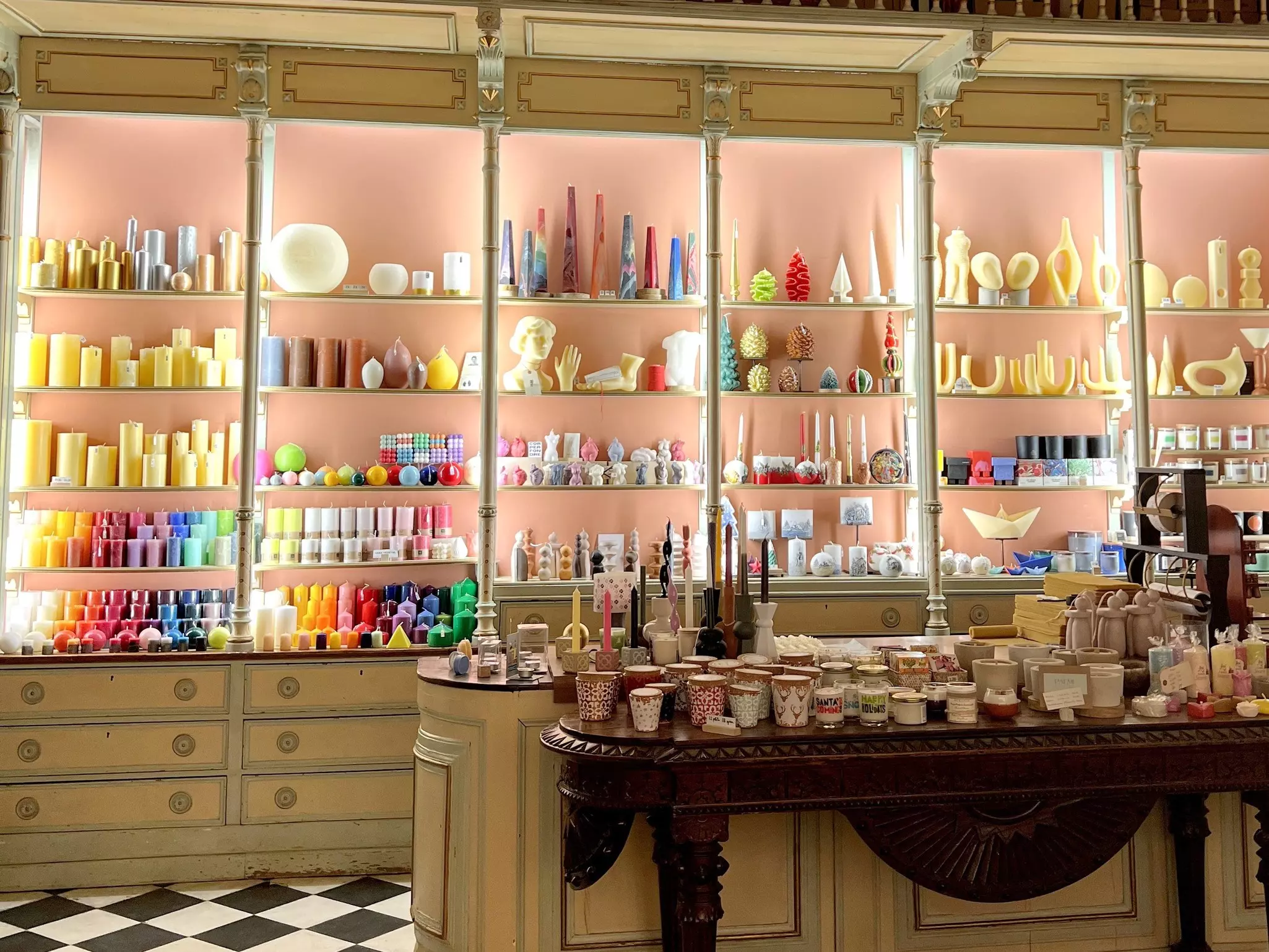 Interior of a traditional candle shop in Barcelona where walls are stacked with shelves of colorful candles