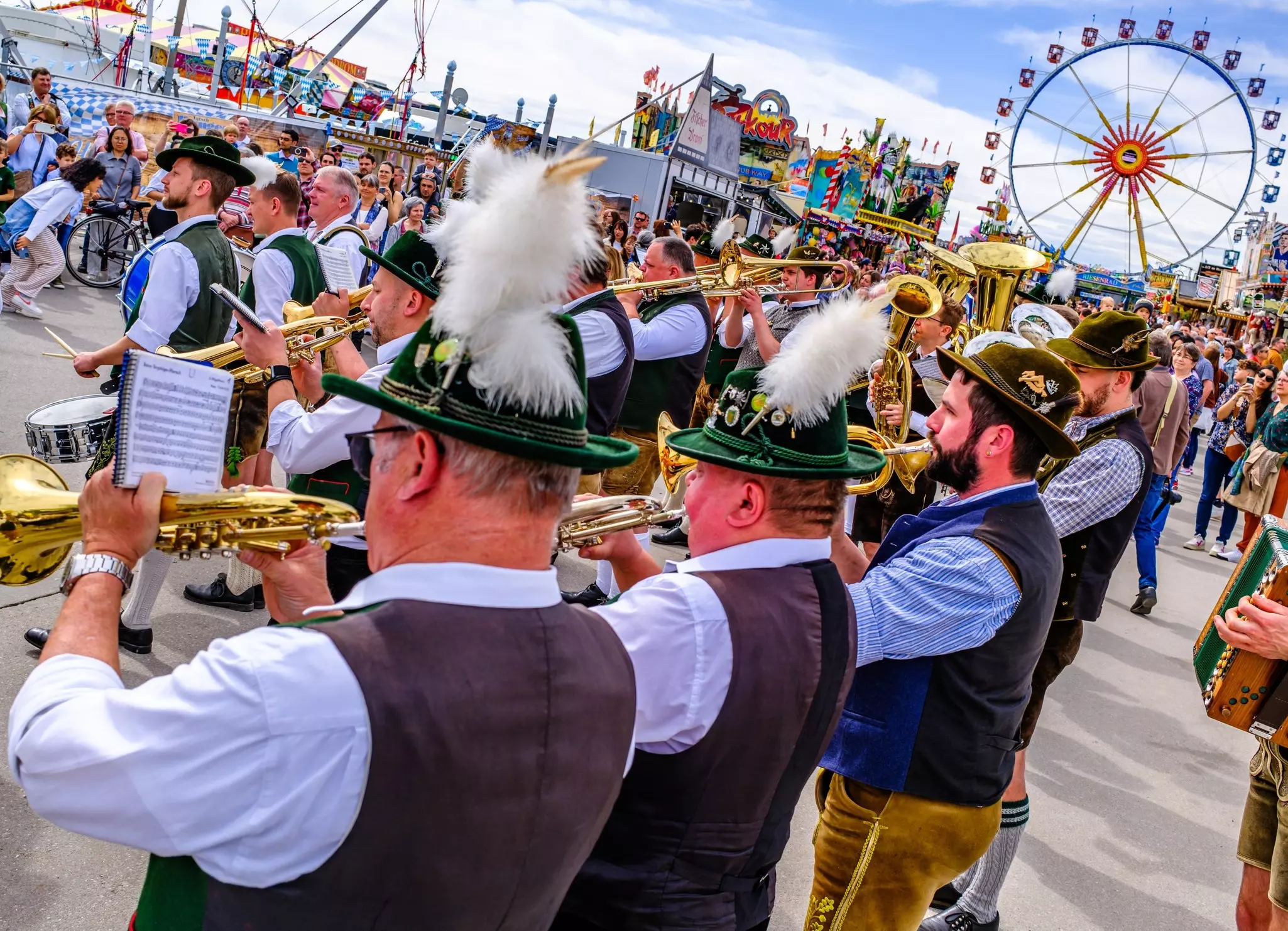 Participants in traditional Bavarian dress play trumpets at Frühlingsfest in Munich, Germany.