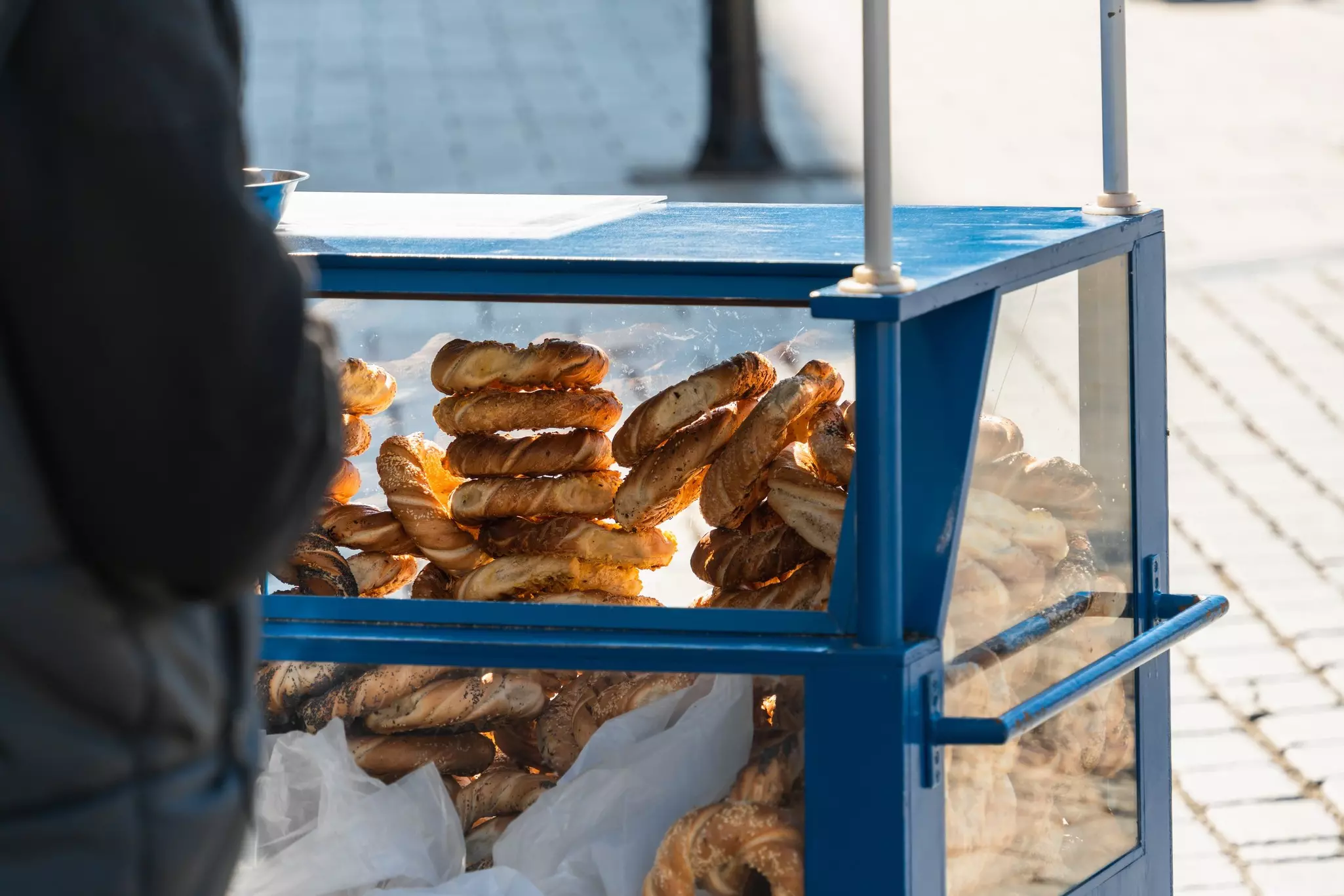 Street stall with Polish bagels in Krakow, round traditional pretzels with poppy seeds, cumin and salt on a sunny day on the city street