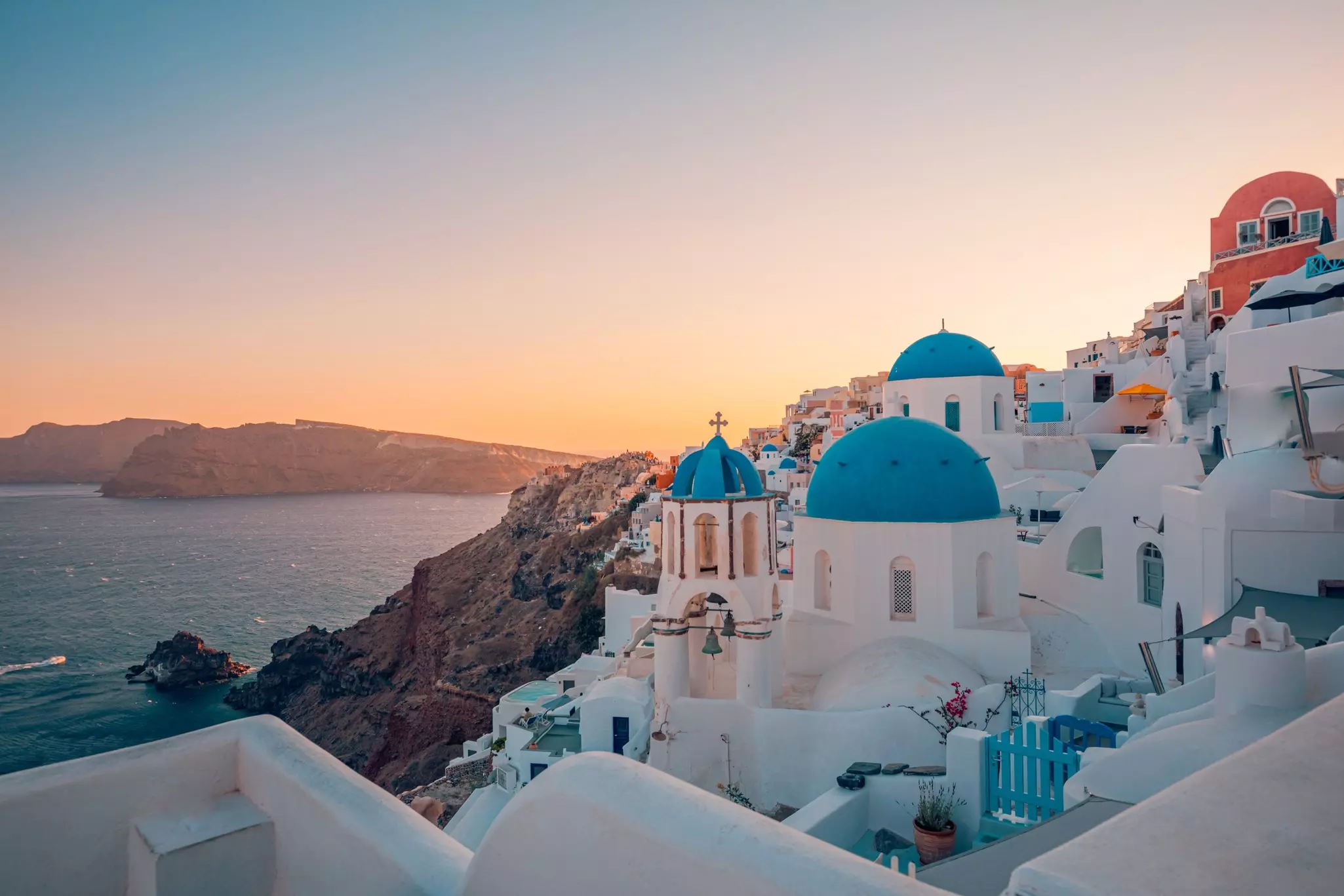 View of scenic sunset with white buildings and colorful rooftops on Santorini.