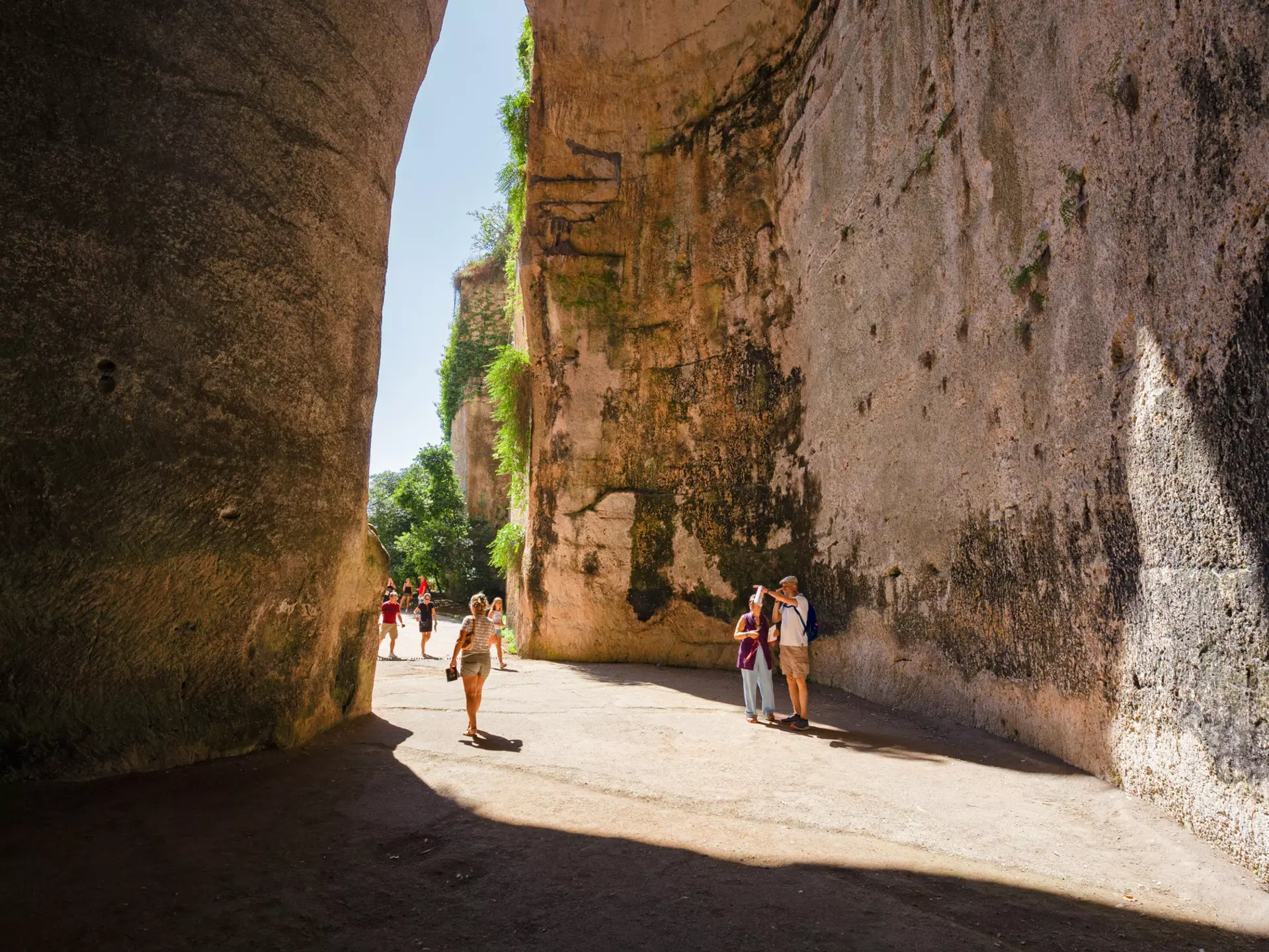 SIRACUSA, ITALY - JULY 18, 2019: Some tourists at the exit of the excavated cave, called Orecchio di Dioniso, near the Greek theater of Syracuse, in Sicily Italy., License Type: media, Download Time: 2025-12-10T16:35:55.000Z, User: sevelynd12, Editorial: true, purchase_order: 56500 - T&R or Kids, job: Global Publishing WIP, client: Dream Trips of Europe, other: Sharon / Dortenzio