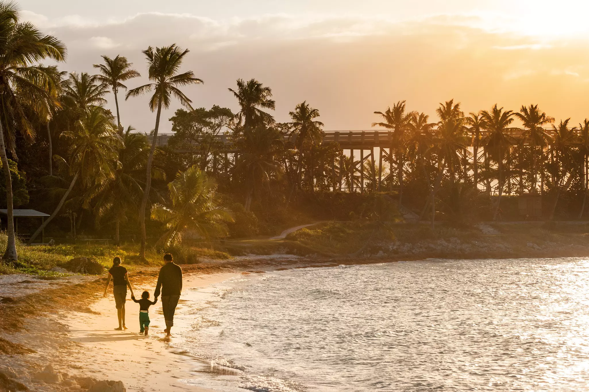 Family strolling on sandy beach of Bahia Honda state park in Florida Keys